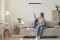Vrouw op bank bedient airconditioner