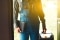 The picture shows an installer in workwear with a toolbox in his hand entering a house.